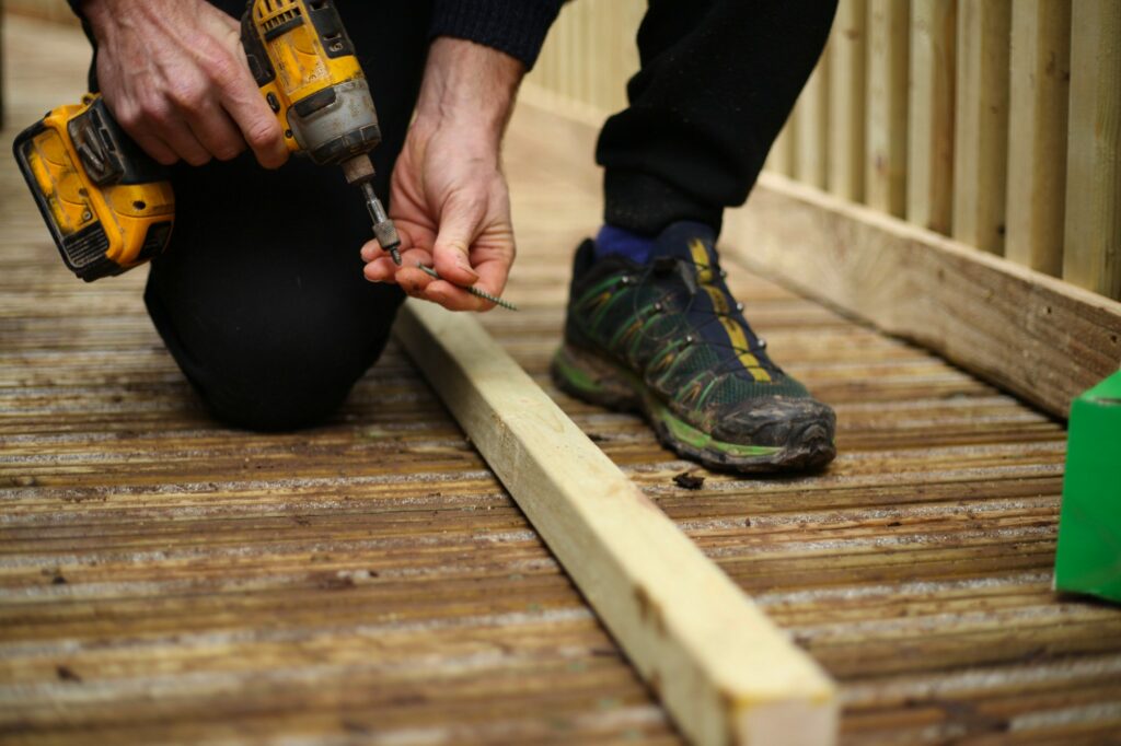 A builder landscaper at work putting a screw in place